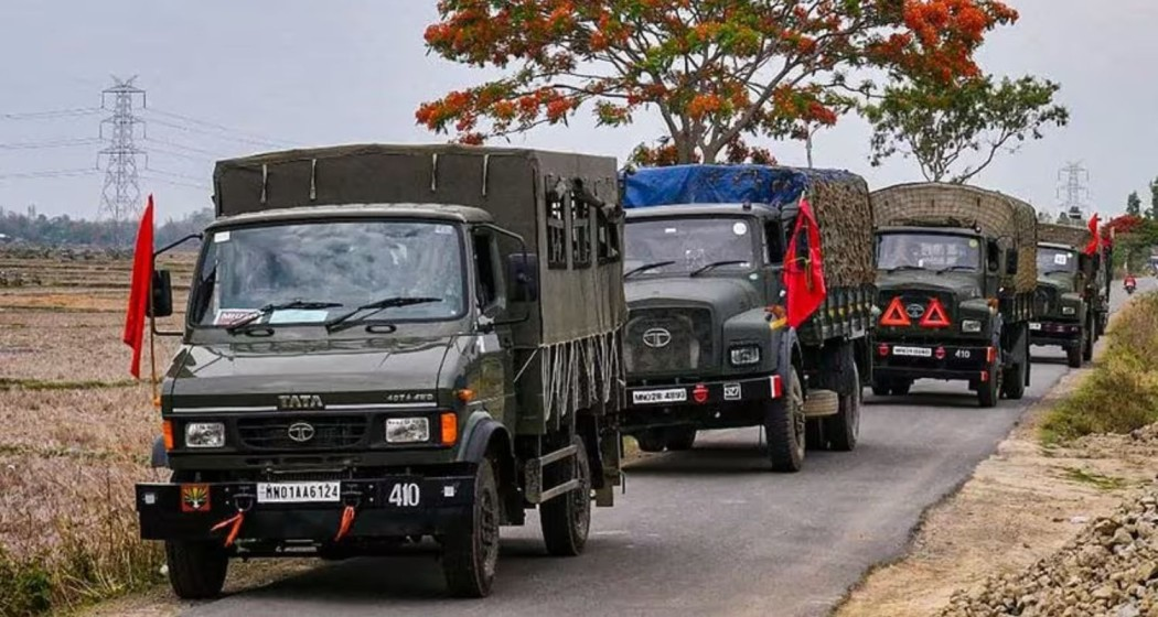 Army and Assam Rifles personnel conduct a flag march.
