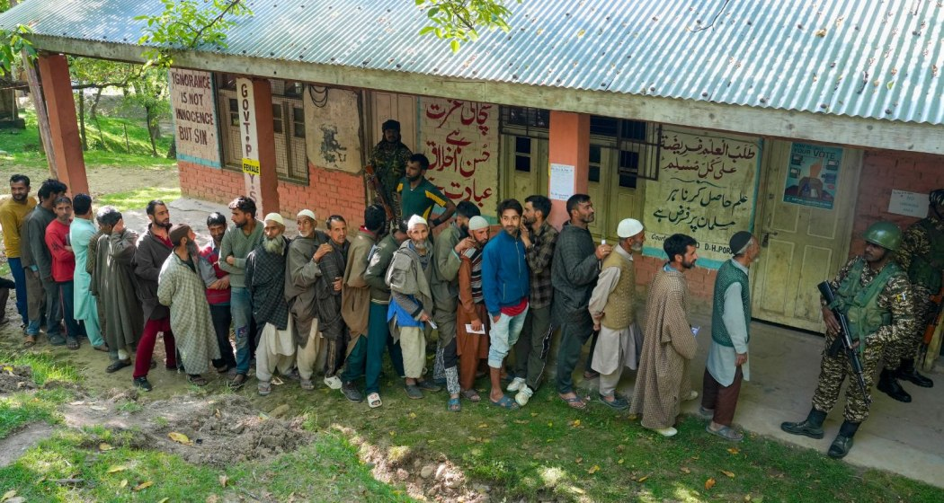People wait in a queue to cast their votes at a polling booth during the sixth phase of Lok Sabha elections, at Noorbabad area in Kulgam district of South Kashmir on Saturday, May 25, 2024.