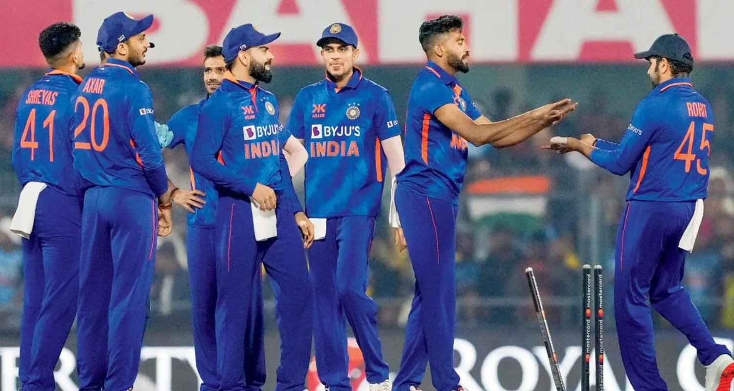 The Indian cricket team celebrates a wicket.