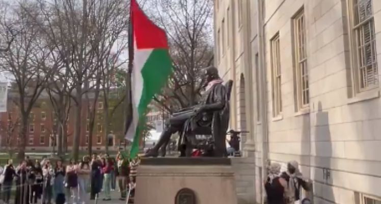 As tensions over the Gaza War grip universities nationwide, Harvard University witnessed a symbolic act of protest as anti-Israel demonstrators raised the Palestinian flag over the John Harvard statue in Harvard Yard.