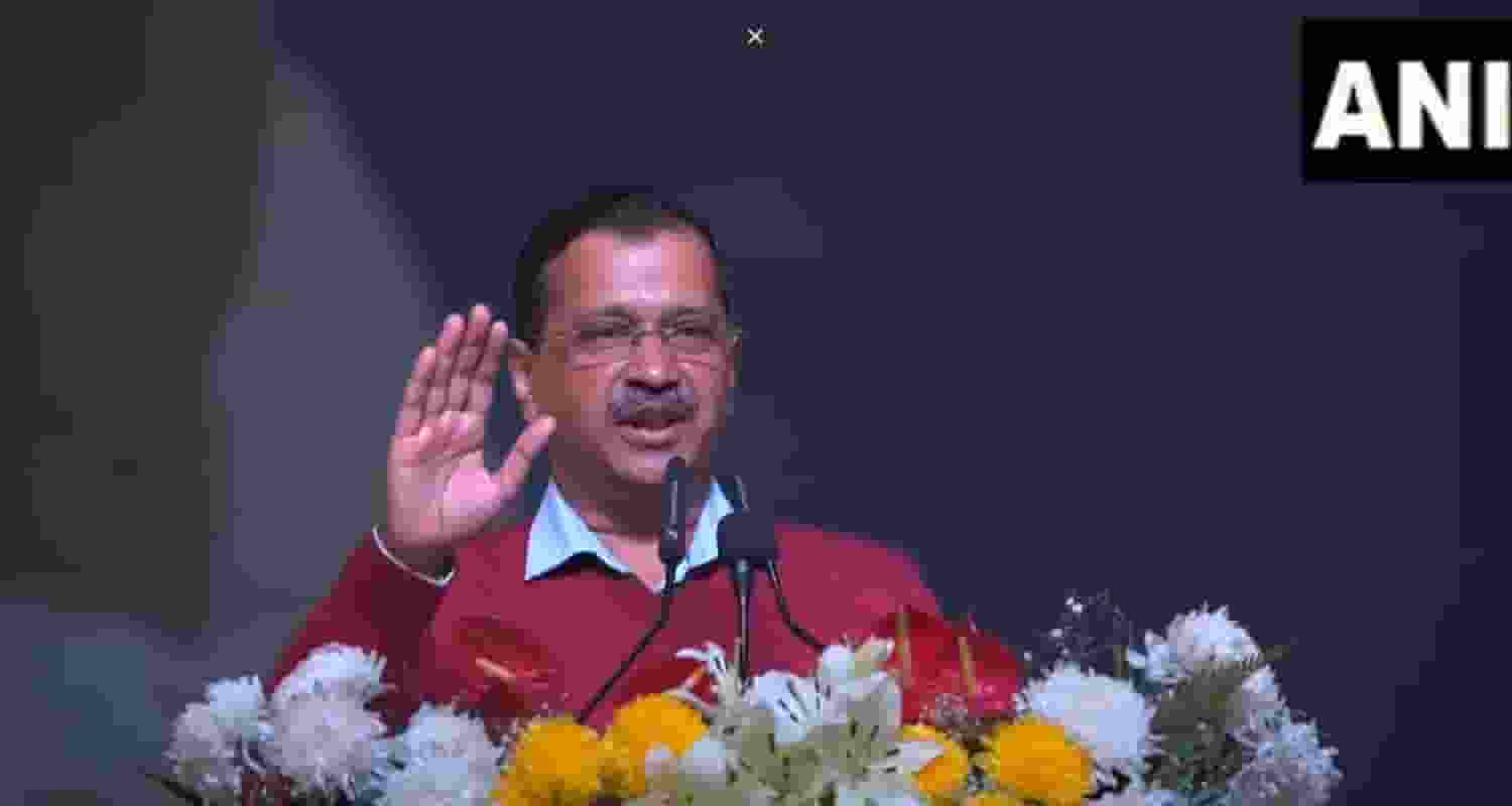 Arvind Kejriwal Delhi Chief Minister wearing a red sweater while speaking to people at a public rally