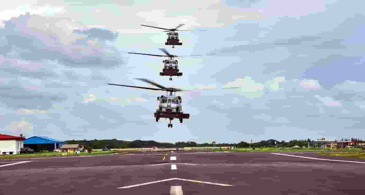 Three MH-60R Seahawk helicopters in a vertical formation above the runway at INS Garuda, signifying their imminent induction into the Indian Navy's air squadron.