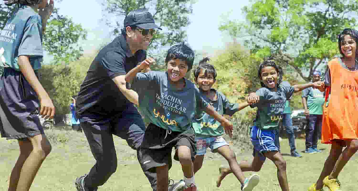 Former cricketer Sachin Tendulkar with wife Anjali Tendulkar pose for group photos with budding football players of Yuwa Foundation, in Ranchi