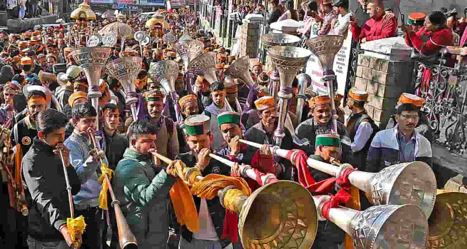 Devotees play musical instruments at a religious procession during the week-long International Shivratri Fair, in Mandi on Friday
