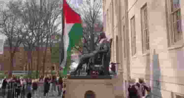 As tensions over the Gaza War grip universities nationwide, Harvard University witnessed a symbolic act of protest as anti-Israel demonstrators raised the Palestinian flag over the John Harvard statue in Harvard Yard.