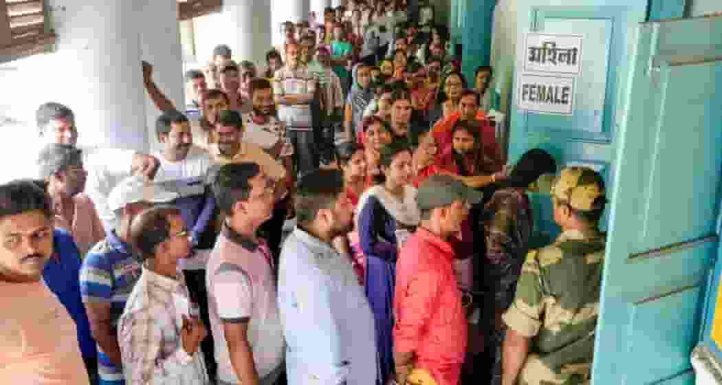 Voters wait in a queue at a polling station to cast their votes for the fourth phase of Lok Sabha elections, in Bardhaman on Monday, May 13, 2024.